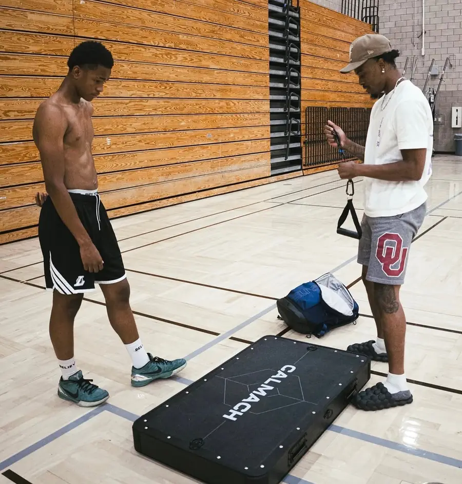 Trainer setting up the Calmach platform with a client in a gym
